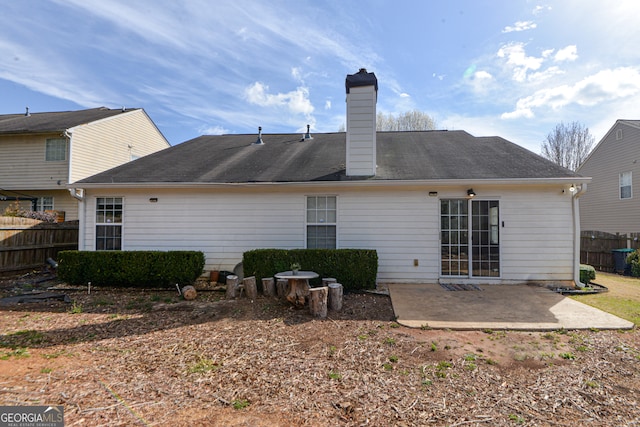 back of house featuring a patio area, fence, and a chimney