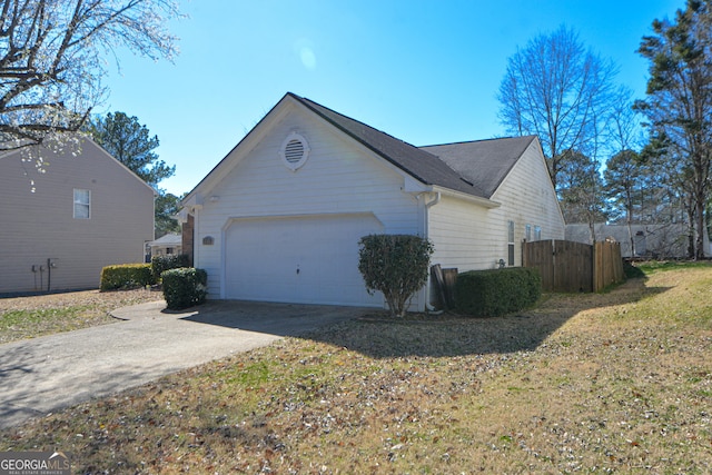 view of side of property featuring an attached garage and concrete driveway