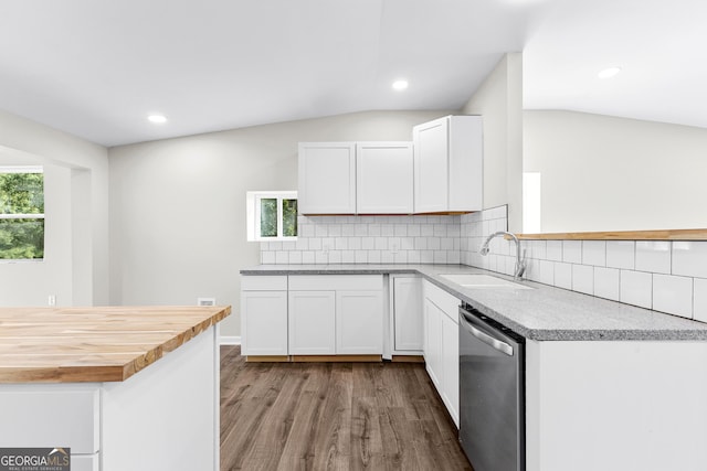 kitchen with wood finished floors, a sink, white cabinets, stainless steel dishwasher, and backsplash