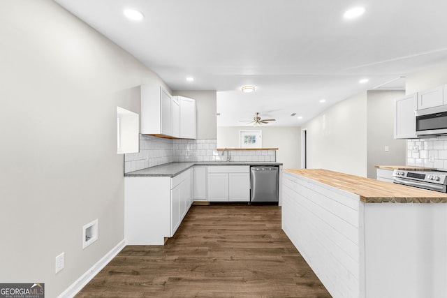 kitchen with appliances with stainless steel finishes, wood counters, dark wood finished floors, and white cabinets