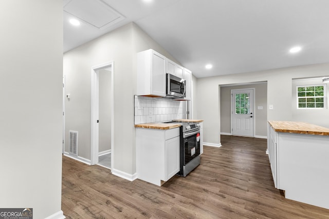 kitchen with stainless steel appliances, tasteful backsplash, visible vents, wooden counters, and white cabinets