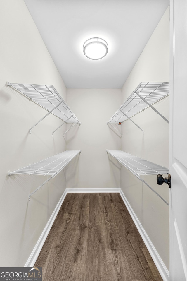 walk in closet with wood finished floors