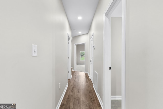 hall featuring dark wood-style floors, recessed lighting, visible vents, and baseboards