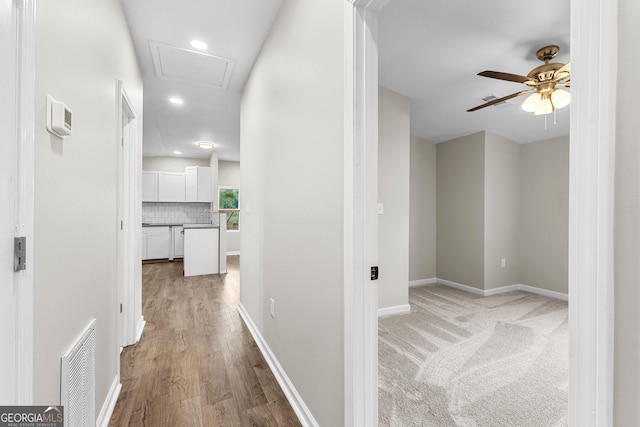 hallway featuring recessed lighting, light wood-type flooring, visible vents, and baseboards