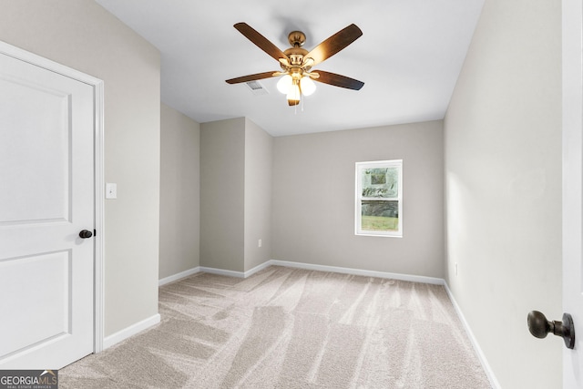 carpeted empty room featuring visible vents, ceiling fan, and baseboards