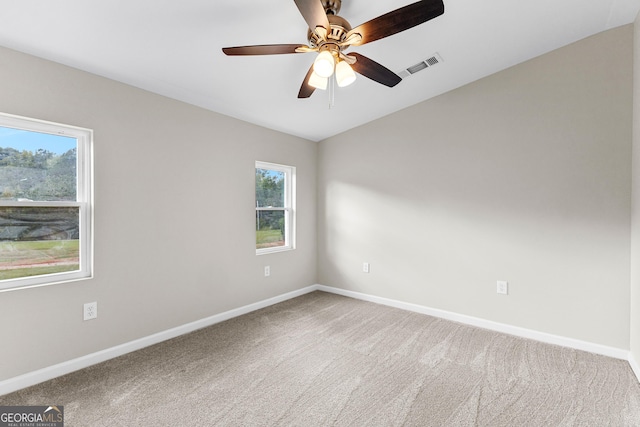 spare room with carpet, visible vents, and baseboards