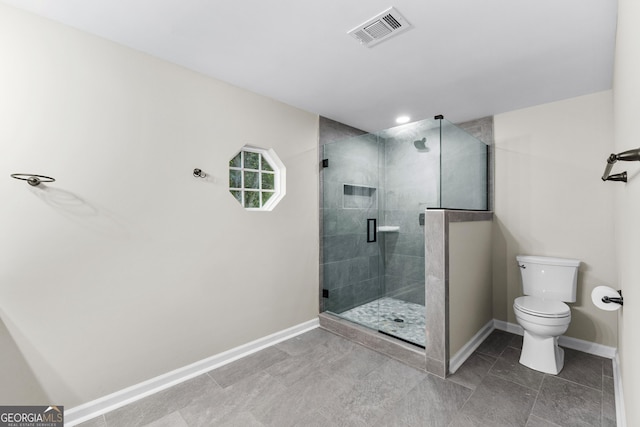 bathroom with toilet, a stall shower, baseboards, and visible vents