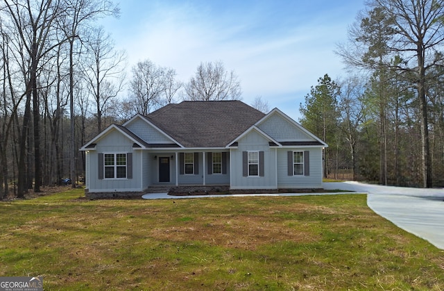 craftsman inspired home with a shingled roof, a front lawn, and board and batten siding