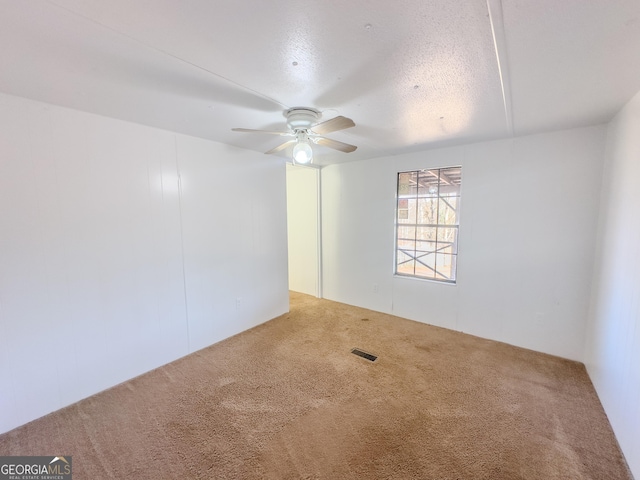 carpeted spare room with ceiling fan and visible vents