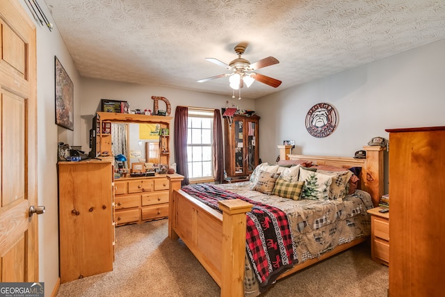 carpeted bedroom with a textured ceiling and a ceiling fan