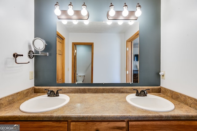 full bath featuring a sink, toilet, and double vanity