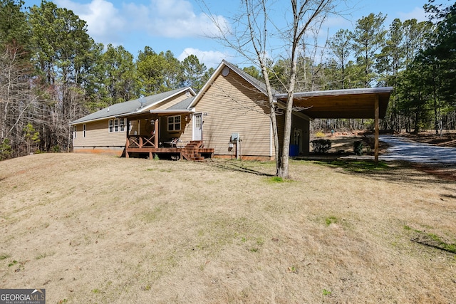 exterior space featuring driveway, an attached carport, crawl space, and a front yard