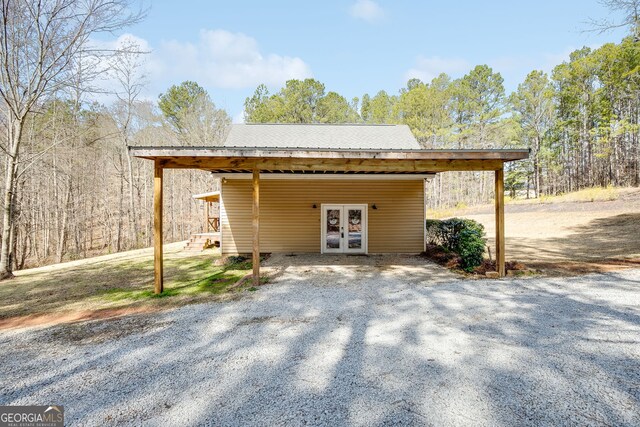 exterior space with driveway, a carport, and french doors