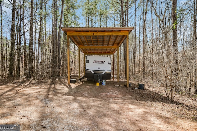 view of vehicle parking with driveway and a carport