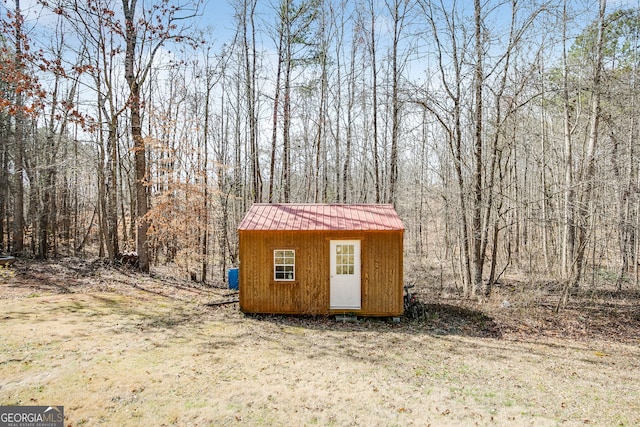 view of shed featuring a view of trees