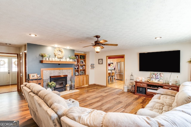 living room with a textured ceiling, wood finished floors, and recessed lighting