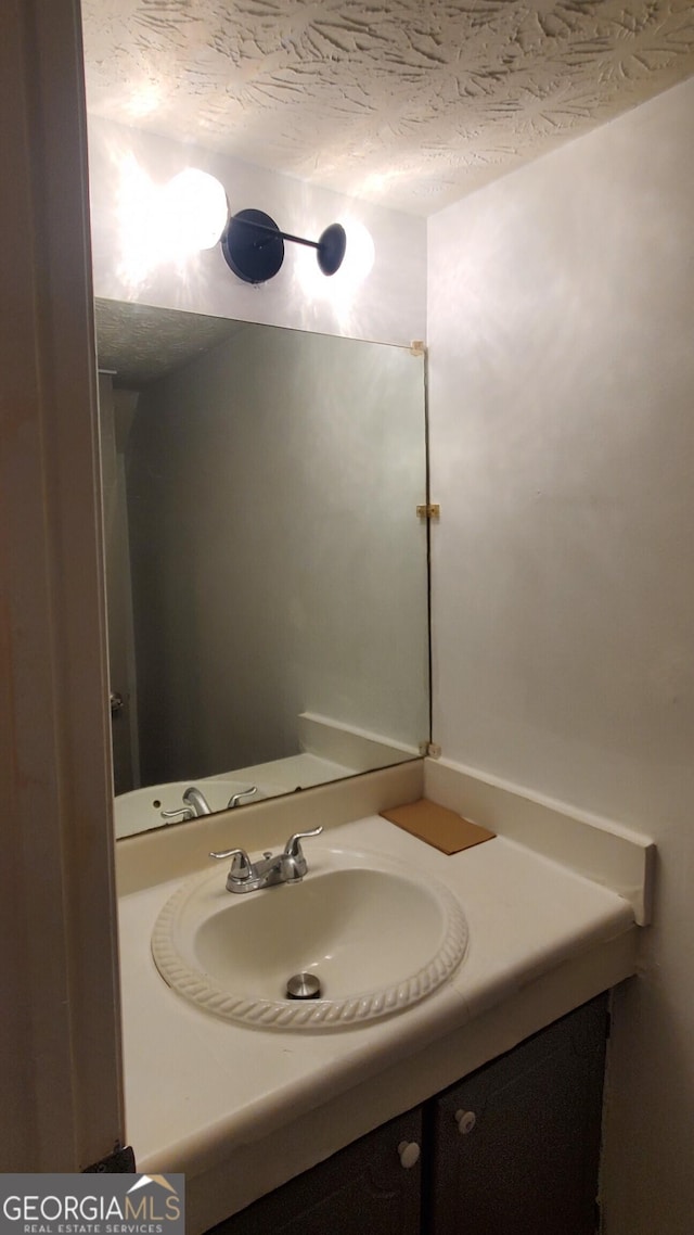 bathroom featuring a textured ceiling and vanity