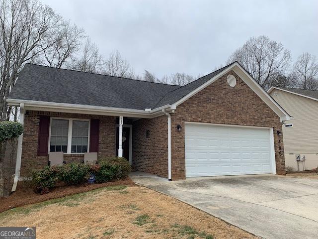 single story home with an attached garage, brick siding, driveway, and roof with shingles