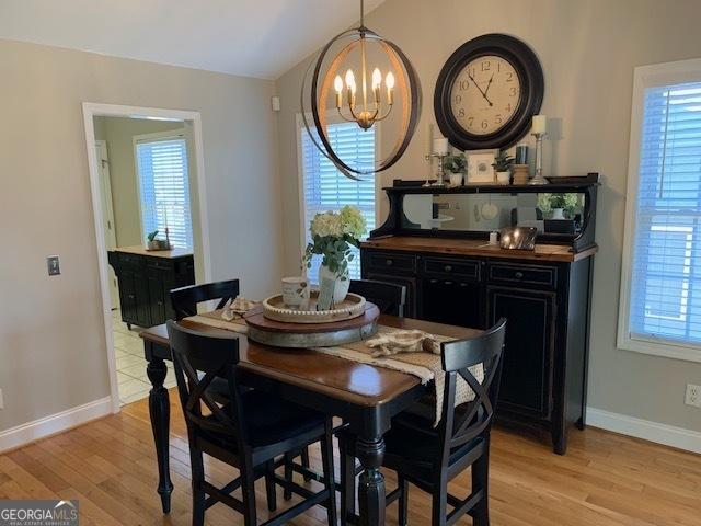 dining room featuring an inviting chandelier, plenty of natural light, and light wood-style floors