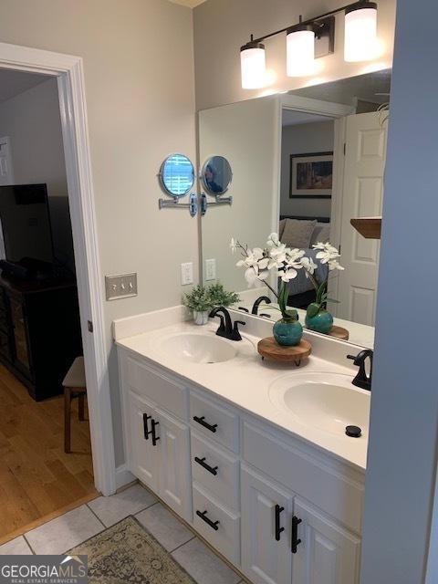 bathroom with a sink, double vanity, and tile patterned floors