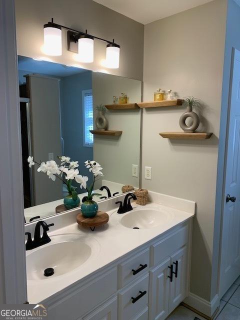 bathroom featuring a sink, double vanity, and tile patterned flooring