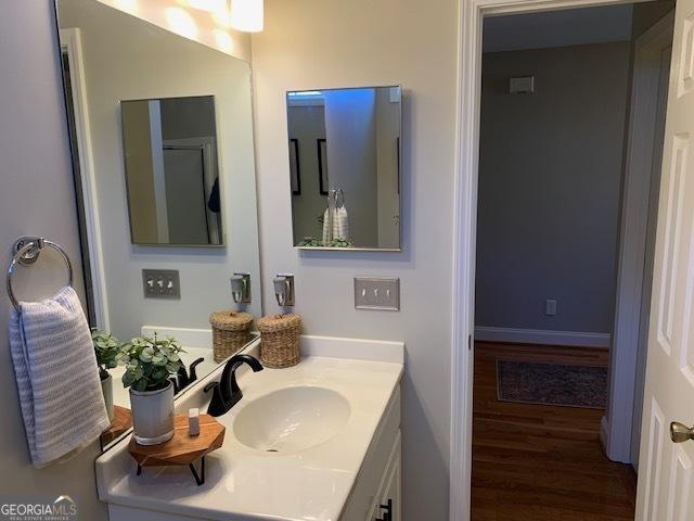 bathroom featuring baseboards, wood finished floors, and vanity