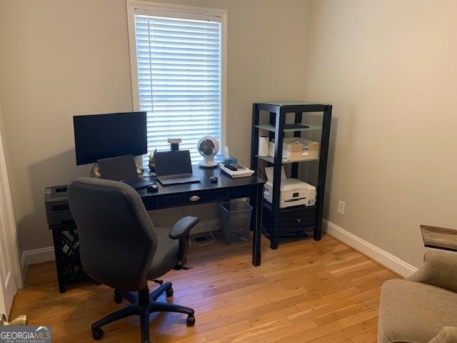 office area featuring light wood-type flooring and baseboards