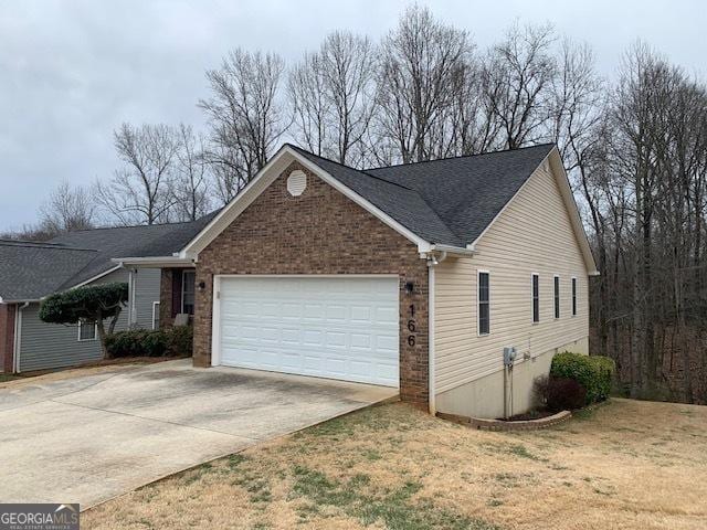 single story home featuring brick siding, concrete driveway, and a garage