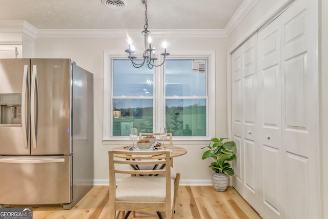 interior space with light wood finished floors, visible vents, crown molding, baseboards, and a chandelier