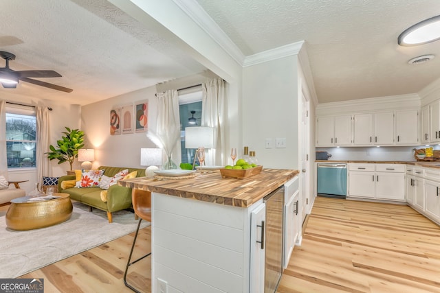 kitchen featuring visible vents, butcher block countertops, open floor plan, stainless steel dishwasher, and light wood-type flooring