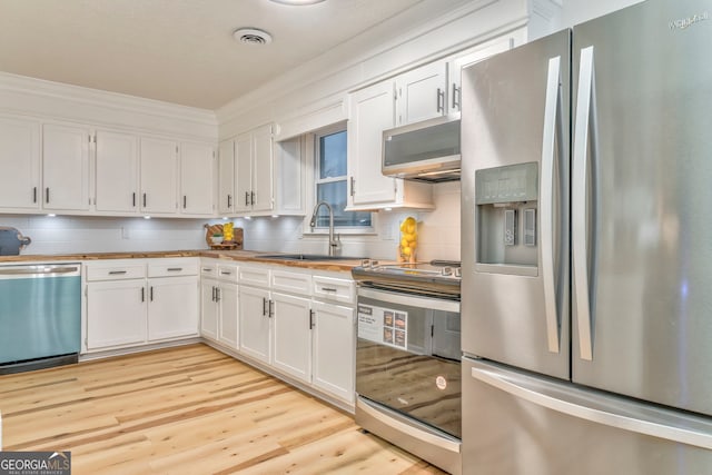 kitchen with a sink, appliances with stainless steel finishes, and white cabinets