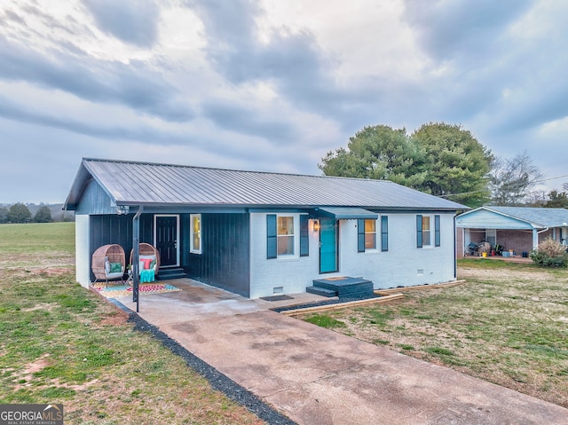 ranch-style house with a front yard, metal roof, brick siding, and crawl space