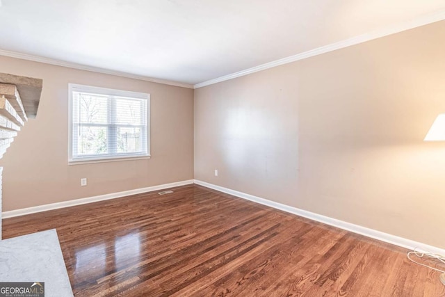 unfurnished room featuring crown molding, baseboards, and wood finished floors