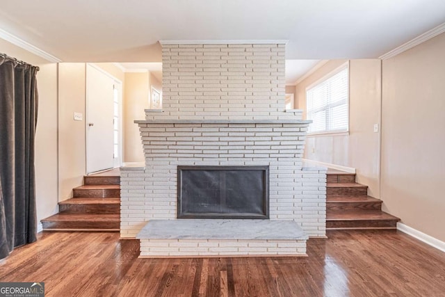 unfurnished living room featuring stairway, ornamental molding, and wood finished floors