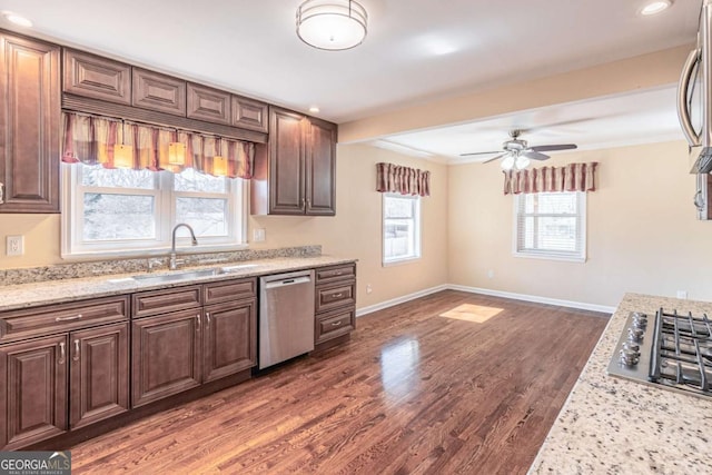 kitchen featuring dark wood-style flooring, appliances with stainless steel finishes, a sink, ceiling fan, and baseboards