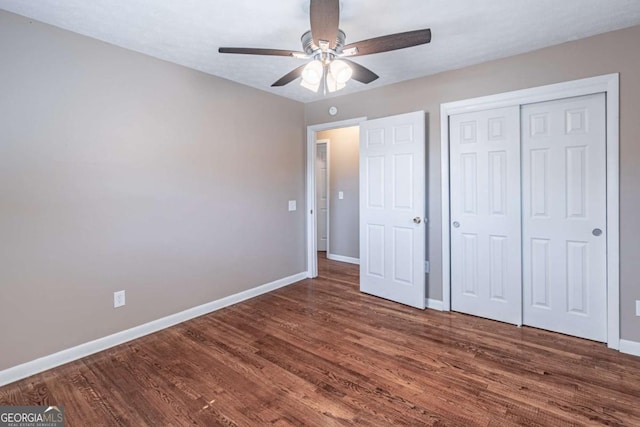 unfurnished bedroom featuring a closet, ceiling fan, baseboards, and wood finished floors