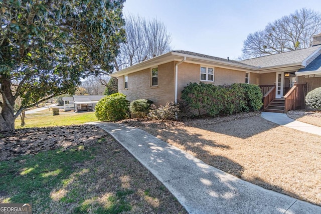 view of side of home with a yard and brick siding