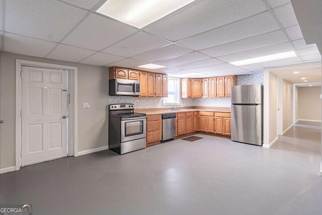 kitchen featuring baseboards, concrete floors, and appliances with stainless steel finishes