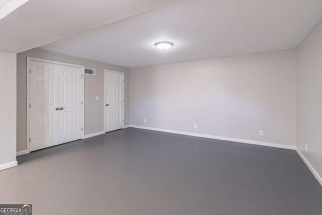 interior space featuring baseboards, visible vents, and finished concrete floors