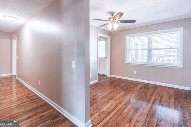 corridor with crown molding, baseboards, a textured ceiling, and wood finished floors