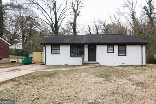 ranch-style house featuring roof with shingles, brick siding, crawl space, and a front yard