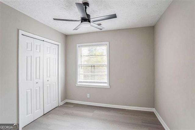 unfurnished bedroom featuring a closet, baseboards, and wood finished floors