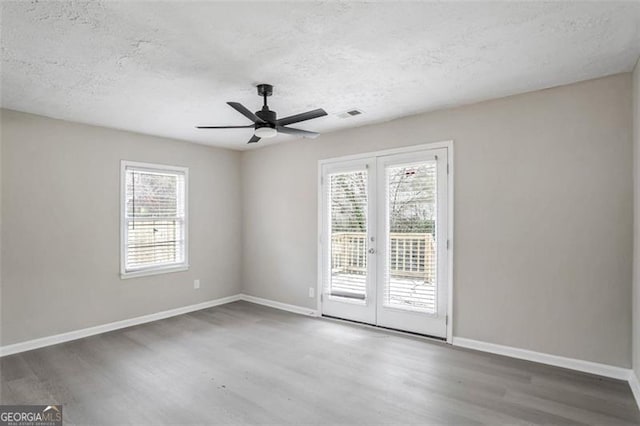 empty room with wood finished floors and a wealth of natural light