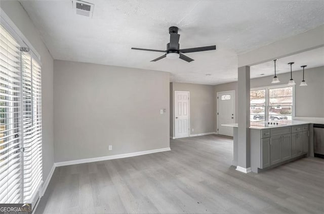 interior space featuring a wealth of natural light, gray cabinets, and light wood-style flooring