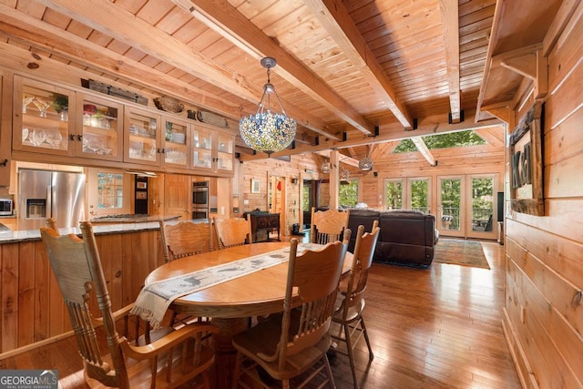 dining room featuring wooden walls, wood ceiling, hardwood / wood-style floors, beamed ceiling, and an inviting chandelier