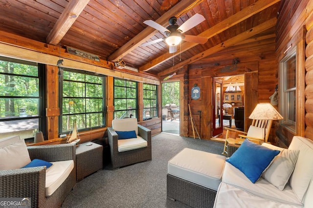 living area with vaulted ceiling with beams, ceiling fan, wooden ceiling, carpet floors, and wood walls