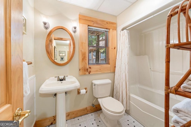 full bathroom featuring shower / bath combo, baseboards, a sink, and toilet