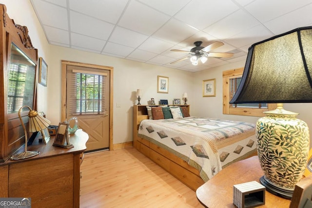 bedroom featuring light wood finished floors and a drop ceiling