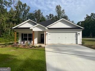 view of front of home with driveway, an attached garage, and a front yard