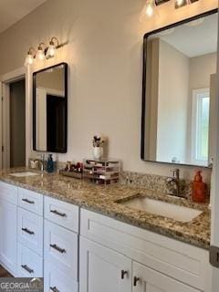 full bathroom with a sink and double vanity